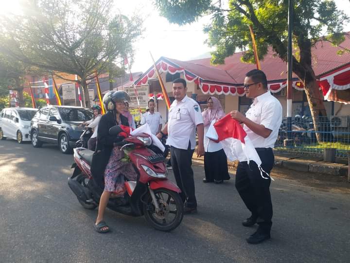 Diskominfo pesisir selatan bagi bagi bendera kepada pengguna jalan raya