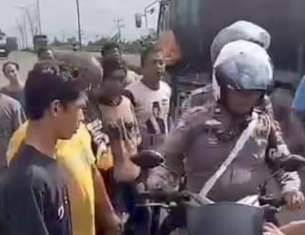 Dua orang polantas terlihat dikerubungi warga yang terpancing emosi